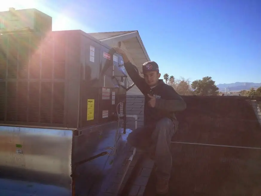HVAC technician performing Heat Pump Repair on a rooftop unit in Running Springs